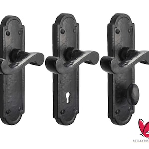 May include: Three black door handles with a curved lever and a keyhole. The handles have a decorative design with a rounded top and bottom.
