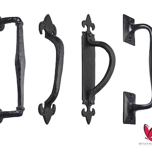 May include: Four black metal door handles with ornate fleur-de-lis designs. The handles are in various styles, including a lever handle, a pull handle, and a door knob.