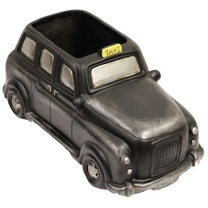 May include: Black and silver vintage-style taxi planter with a yellow "TAXI" sign on the roof. The planter has a rectangular opening for planting.