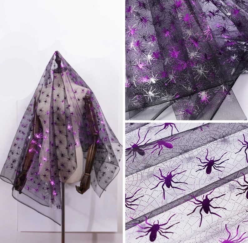 May include: Black sheer fabric featuring a spider web design with metallic purple spider accents. The fabric is draped over a mannequin. Suitable for Halloween or themed crafts. The fabric is see-through.