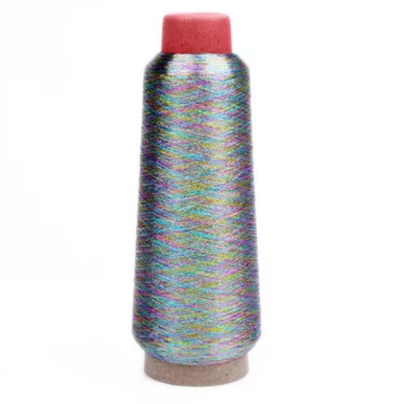 May include: A spool of iridescent thread with a red top and a cardboard base. The thread has a metallic sheen, reflecting multiple colors. The spool is cylindrical with a slight taper.