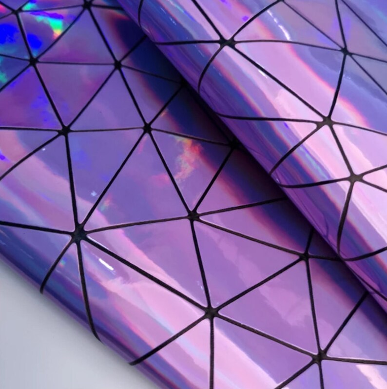 May include: Holographic purple vinyl sheet with a geometric triangular pattern. The vinyl reflects a rainbow of colours. The sheet is folded over, showing the glossy surface and the black lines that define the geometric shapes.