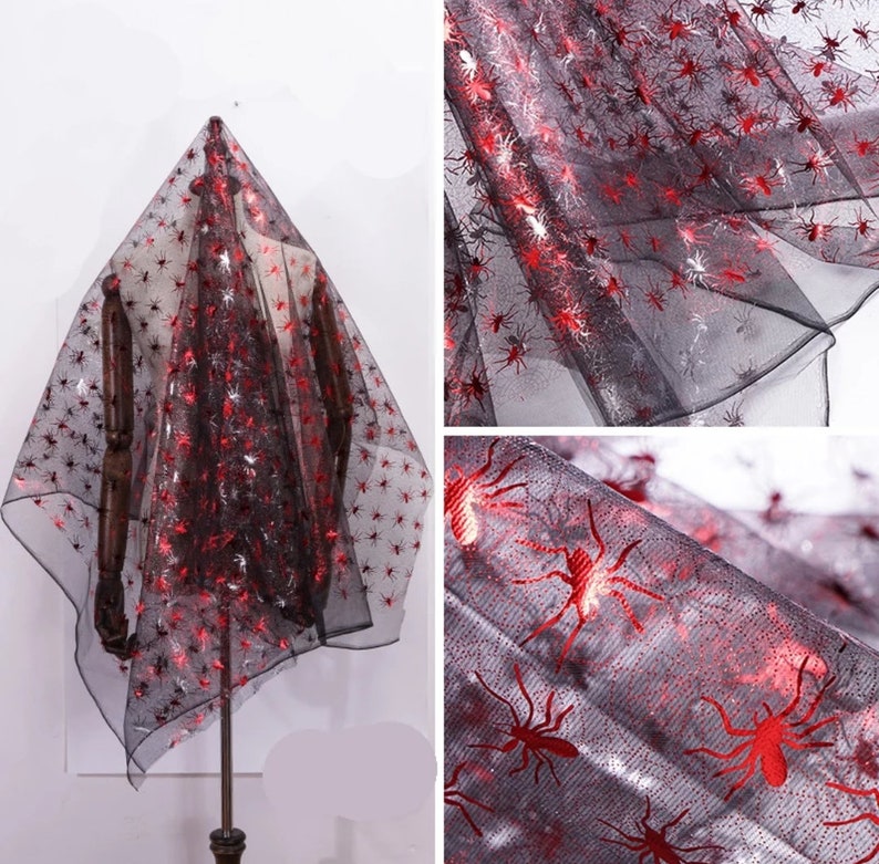 May include: Black sheer fabric decorated with red and silver spider motifs. The material is displayed over a mannequin, highlighting its texture and design. Suitable for Halloween decorations or themed crafts.