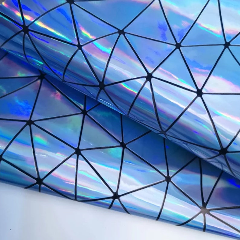 May include: Close-up of a sheet of iridescent blue material with a geometric pattern of black lines. The material reflects light, creating a rainbow effect. The pattern consists of interconnected triangles.