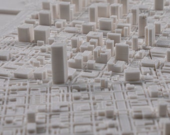 Puede incluir: Un modelo de ciudad en 3D impreso en blanco con edificios altos y calles.