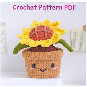May include: A crocheted sunflower in a brown pot with a smiling face. The sunflower has yellow petals, a brown center, and green stems. The text "Crochet Pattern PDF" is at the top of the image.