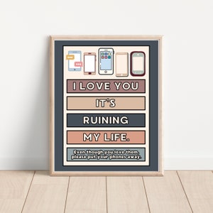 May include: A dark blue poster with a light brown frame. The poster features a series of five colorful cell phone icons with the text "I LOVE YOU IT'S RUINING MY LIFE. Even though you love them, please put your phones away."