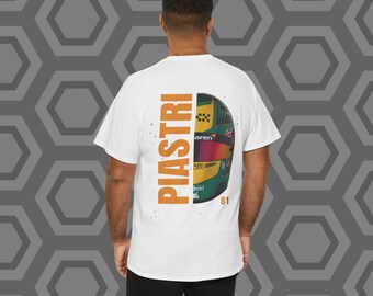 May include: White t-shirt with an orange graphic of the word "PIASTRI" and a green and yellow racing helmet with the number "81" on it.