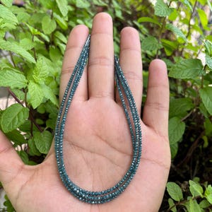 K&ouml;nnte beinhalten: Eine Halskette aus blauen Diamantperlen. Die Halskette ist mehrlagig und scheint aus kleinen, facettierten Perlen zu bestehen.