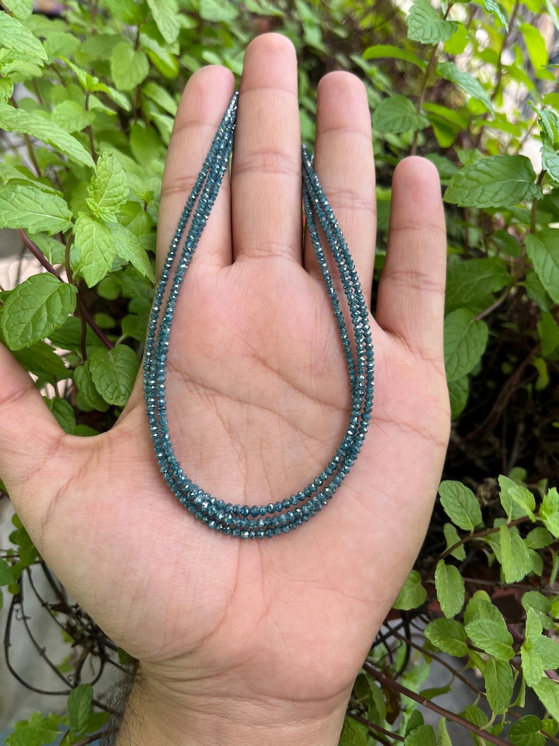 K&ouml;nnte beinhalten: Eine Halskette aus blauen Diamantperlen. Die Halskette ist mehrlagig und scheint aus kleinen, facettierten Perlen zu bestehen.