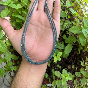 K&ouml;nnte beinhalten: Eine Halskette aus kleinen, blauen, facettierten Perlen. Die Halskette ist mehrlagig und scheint aus Edelsteinen zu bestehen.