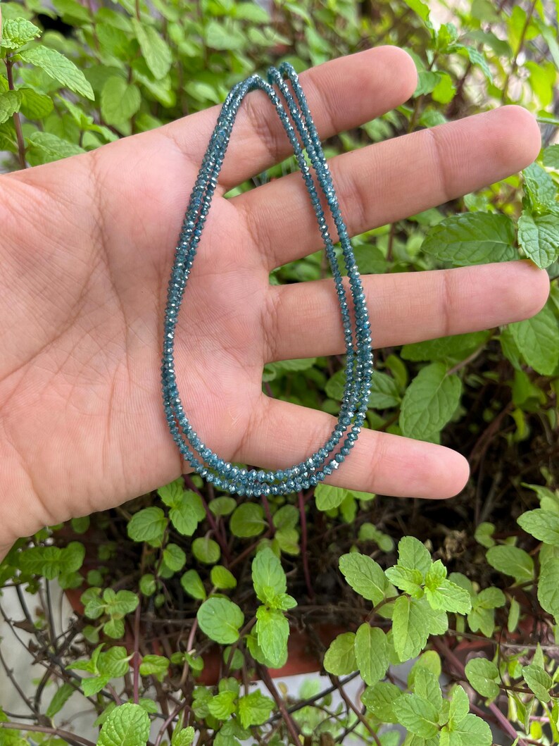 K&ouml;nnte beinhalten: Eine Halskette aus kleinen, blauen, facettierten Edelsteinen. Die Halskette ist doppelf&auml;dig und scheint aus nat&uuml;rlichen Steinen zu bestehen.