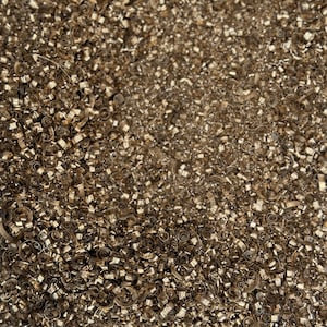 Op de afbeelding: Een close-up van een stapel glanzende, gouden metalen snippers. De snippers zijn dicht opeengepakt en creëren een textuur.