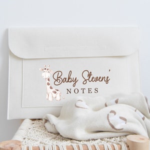 May include: A white canvas envelope with a brown giraffe illustration and the text "Baby Stevens' NOTES" printed on the front.
