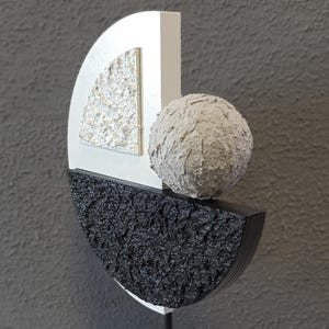 May include: Abstract sculpture made of wood and painted in black, white, and gray. The sculpture features a sphere, a half-circle, and a quarter-circle.