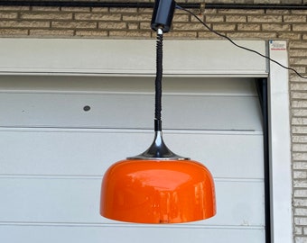 May include: A black and chrome pendant light with an orange glass shade. The light is hanging from a black cord and is suspended from a metal rod.