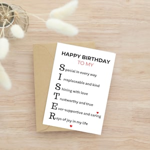 May include: A birthday card with the message "Happy Birthday To My Sister" in black text. The card's message is an acrostic poem, with each letter of "SISTER" spelling out a positive attribute. The card is on a wooden surface.