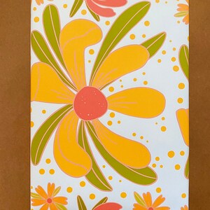 May include: White wrapping paper with a repeating pattern of yellow, orange, and green stylized flowers. The flowers have a retro 1970s aesthetic.