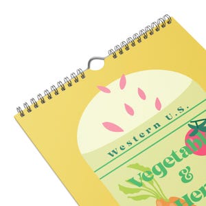 May include: A spiral-bound calendar with a yellow cover featuring a design of vegetables and herbs. The text "Western U.S. Vegetables & Herbs" is visible. The calendar has a metal spiral binding and a hole for hanging.