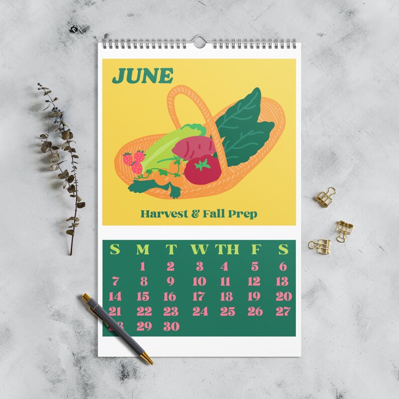 May include: A spiral-bound calendar for June with a yellow background featuring a basket of produce. The text "Harvest & Fall Prep" is below the illustration. The calendar grid is green with pink numbers.