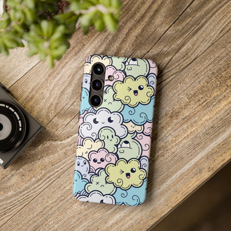 May include: A phone case with a colorful cartoon design featuring clouds with faces. The case has a camera cutout with three lenses.