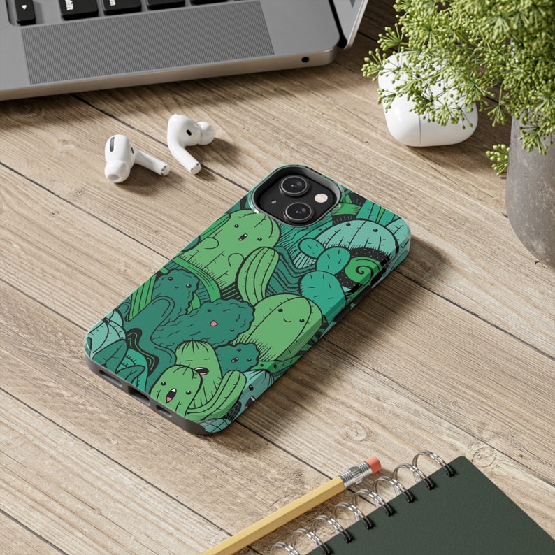 Peut inclure: Une coque de t&eacute;l&eacute;phone verte avec un motif de cactus et de succulentes en dessin anim&eacute;. La coque a une d&eacute;coupe pour l'appareil photo du t&eacute;l&eacute;phone.