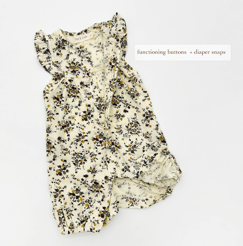 May include: A white floral print baby onesie with ruffled sleeves and a button closure. The onesie has functioning buttons and popper fastenings.