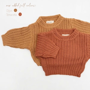 May include: Two long-sleeve knit sweaters with ribbed crew necklines, cuffs, and hems. One sweater is dijon yellow and the other is terracotta orange. Text in the image reads: new added fall colors: Dijon, Terracotta.