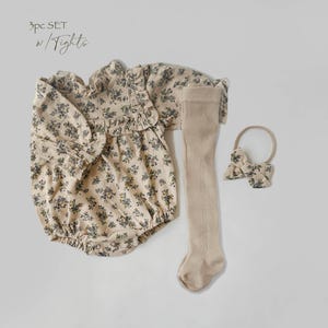 May include: A 3-piece baby outfit set in a floral print. The set includes a long-sleeved bodysuit, tights, and a headband with a bow.