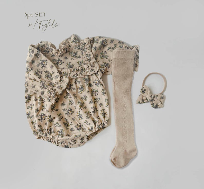 May include: A 3-piece baby outfit set in a floral print. The set includes a long-sleeved bodysuit, tights, and a headband with a bow.