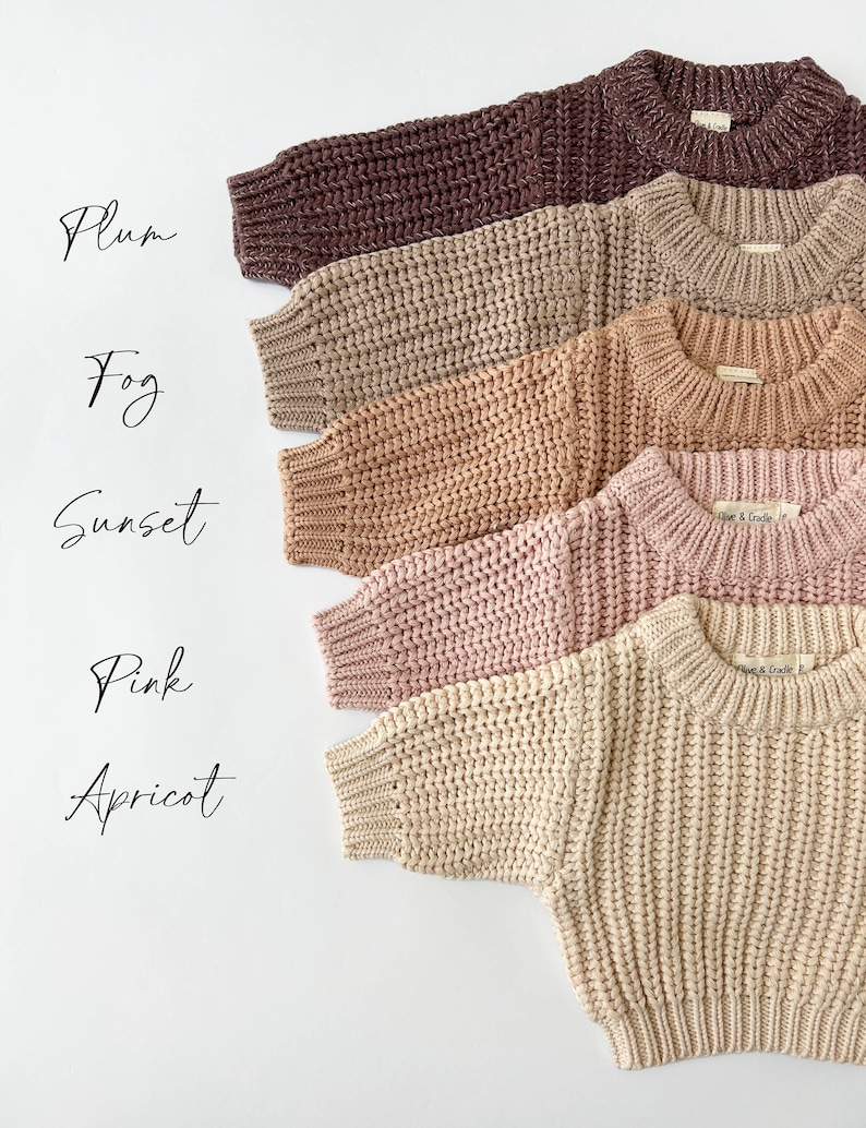 May include: Five long-sleeve sweaters in a chunky knit texture, arranged vertically in colors labeled Plum, Fog, Sunset, Pink, and Apricot. Each sweater features a ribbed crew neckline, ribbed cuffs, and a hem, with a small brand tag inside the collar.