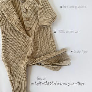 May include: A knitted baby romper in a light muted green and taupe color. The romper has a double zipper, functioning buttons, and is made of 100% cotton yarn.