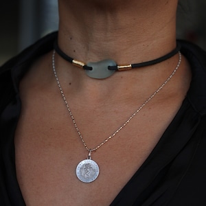 Light blue sea glass choker on black soft leather cord with gold wire wrap components. (It’s about 13.5 inch long)