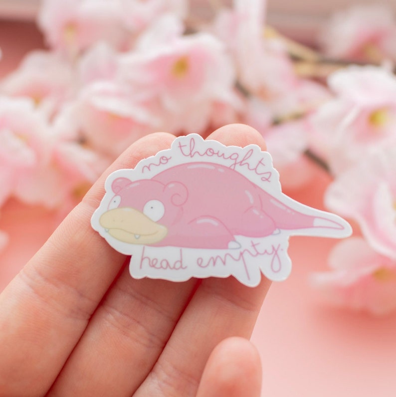 May include: A pink sticker with a cartoon pink Pokemon character with the text "no thoughts head empty".