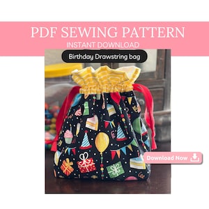 May include: A black drawstring bag with a birthday theme. The bag is decorated with colorful party hats, balloons, cake, and presents. The bag has yellow and white striped fabric at the top and red drawstrings.