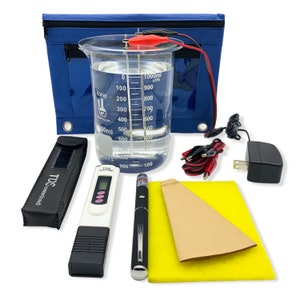May include: A blue zippered pouch, a clear beaker with water, a TDS meter, a black pen, a brown filter paper, a yellow sponge, and a black power adapter with a cord. The beaker has markings for 1000 ml, 900 ml, 800 ml, 700 ml, 600 ml, 500 ml, 400 ml, 300 ml, 200 ml, 100 ml, and 0 ml.