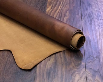 Puede incluir: Un rollo de cuero marrón con un reverso de color beige. El cuero está enrollado y se encuentra sobre una superficie de madera.
