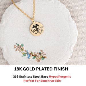 May include: Gold plated necklace with a round pendant featuring a medical symbol, a heart, and the name "Melissa". The pendant is on a white plate with a floral design. 18K Gold Plated Finish. 316 Stainless Steel Base Hypoallergenic. Perfect For Sensitive Skin.