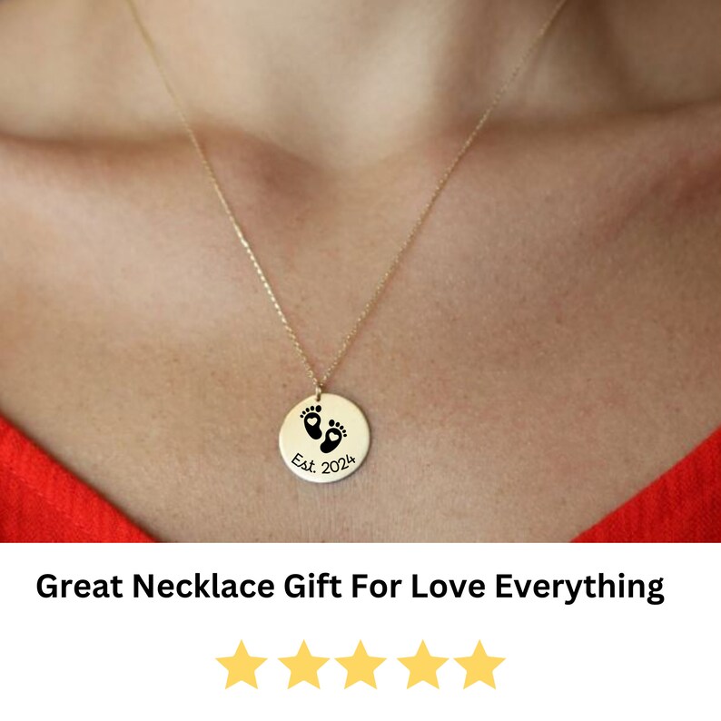 May include: Gold necklace with a round pendant featuring a pair of baby footprints and the text "Est. 2024".