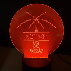 May include: Red illuminated acrylic sign with a stylized tower and lightning bolts. The sign reads "N2TVP" and "FN22AF".