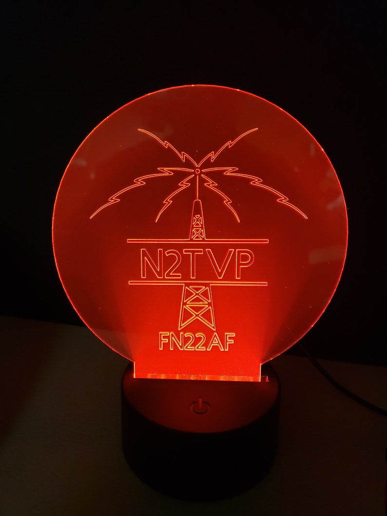 May include: Red illuminated acrylic sign with a stylized tower and lightning bolts. The sign reads "N2TVP" and "FN22AF".