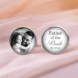 May include: A pair of cufflinks with a black and white photo of a father and daughter on one cufflink and the text "Father of the Bride 02.19.24" on the other cufflink.