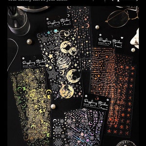 Könnte beinhalten: Eine Sammlung dekorativer Aufkleber mit Himmels- und Blumendesigns. Die Aufkleber haben goldene, silberne und irisierende Folienakzente. Auf den Aufklebern steht "Dazzling Sticker" und "Your destiny can be your doom."