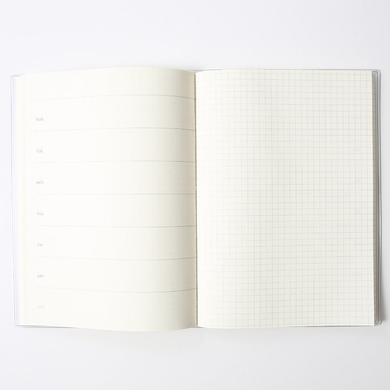 May include: An open notebook with a weekly planner on the left page and a gridded page on the right. The weekly planner has spaces for each day of the week, Monday through Sunday.