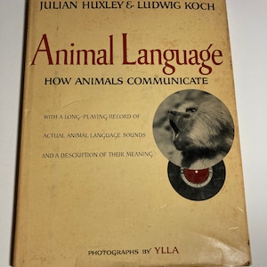 May include: A book cover with a tan background and the title "Animal Language: How Animals Communicate" in red lettering. The cover also features a photograph of a baboon with its mouth open, as well as a black and white record.