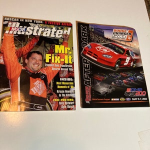 Puede incluir: Dos revistas, una con una portada roja, blanca y azul con un piloto de NASCAR con el texto "Mr. Fix-It" y la otra con una portada roja con un coche de carreras rojo con el texto "Dodge Charger 500".