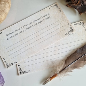 May include: Two blank cards with ornate borders and lined paper. The top card has the text "WITH EACH WORD I WEAVE AND LINE I WRITE, MY DESIRES ARE MANIFESTED BY FIRE & LIGHT..." The bottom card has the text "LIGHT..."