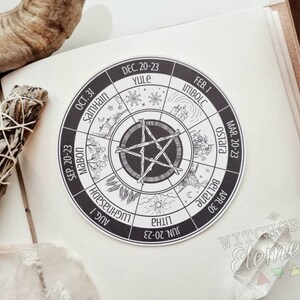 May include: A black and white wheel with the names of the eight pagan holidays and their dates. The wheel is divided into eight sections, each with a different symbol representing the holiday. The center of the wheel features a five-pointed star.