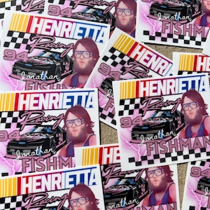 May include: A collection of stickers featuring a racing theme. Each sticker displays the text "Henrietta Racing" with a race car graphic, the number 94, and the name "Jonathan Fishman". The stickers have a pink, black, and white color scheme.