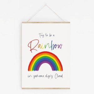May include: A white poster with the text "Try to be a Rainbow in someone else's Cloud" and a rainbow illustration.